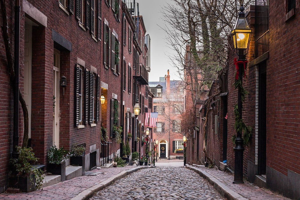 Cobblestoned Acorn Street on Beacon Hill, Boston, lined with brick townhouses and a gas lamp