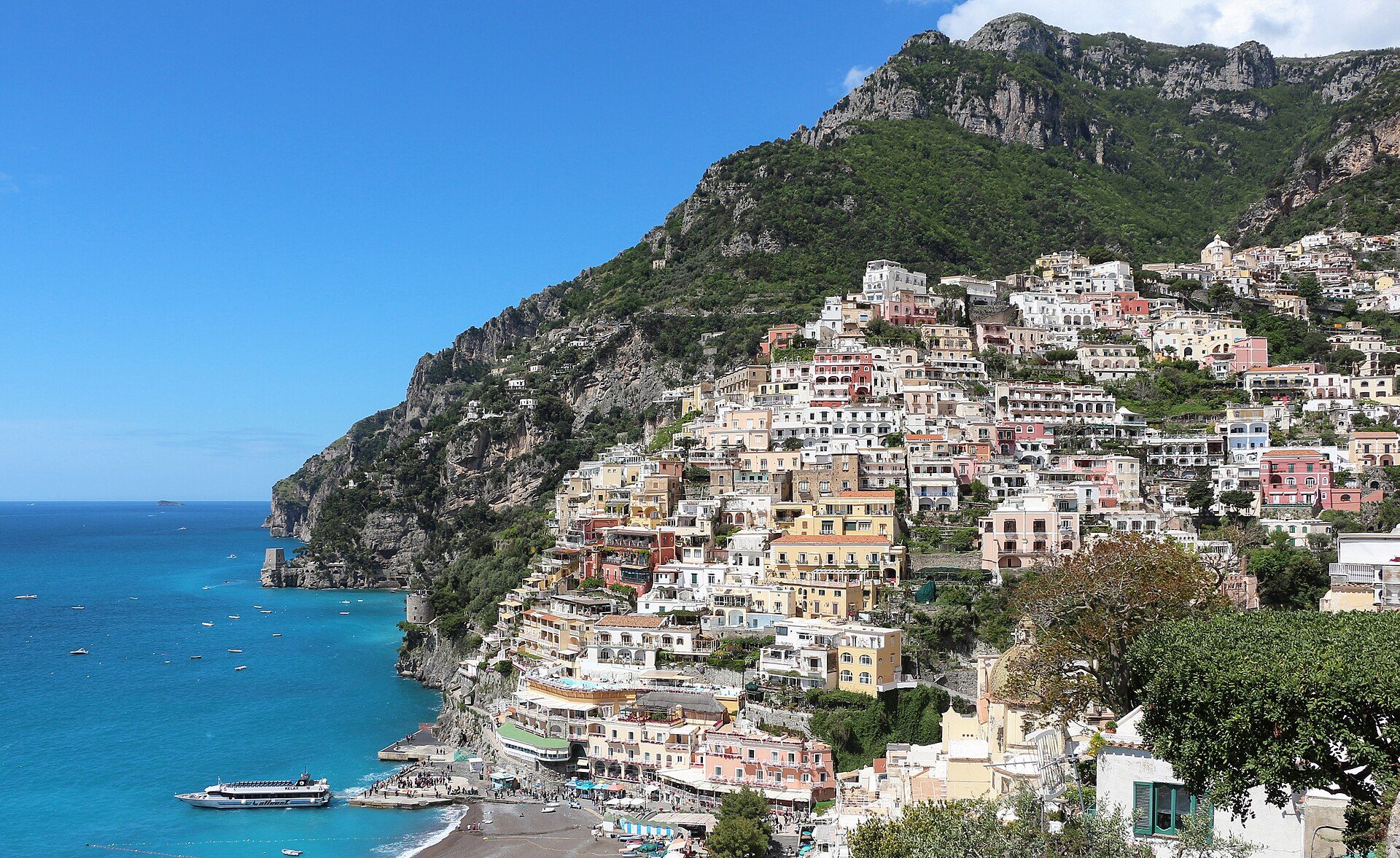 Pastel houses stacked down the cliffside above the sea at Positano on the Amalfi Coast