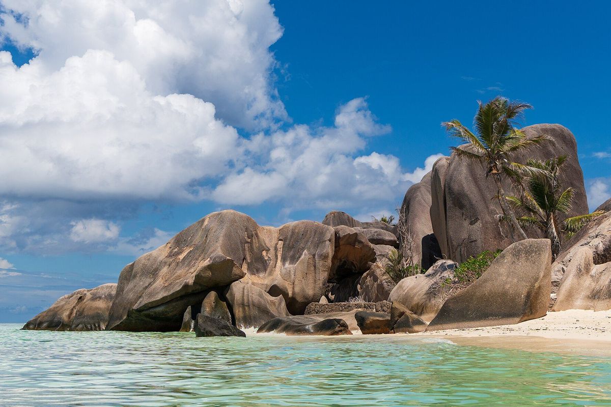 Granite boulders and palms above shallow turquoise water at Anse Source d'Argent, Seychelles